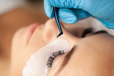 Kirpik uzatma işlemi, profesyonel bir stilist kadınların kirpiklerini uzatır.