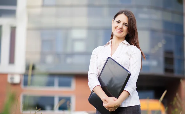 Mujer de negocios feliz sosteniendo portátil y sonriendo — Foto de Stock