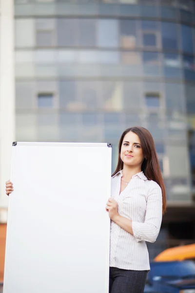 Mujer de negocios sosteniendo anuncio de pancarta en su oficina — Foto de Stock