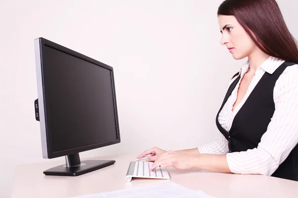 Cheerful businesswoman working at her desk looking at camera in — Stock Photo, Image