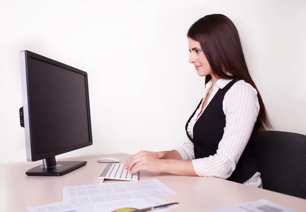 Alegre mujer de negocios trabajando en su escritorio mirando a la cámara en — Foto de Stock