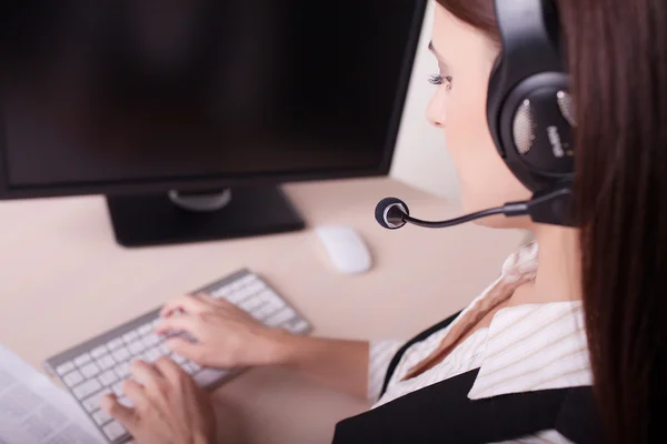 Businesswoman with headset working on computer — Stock Photo, Image