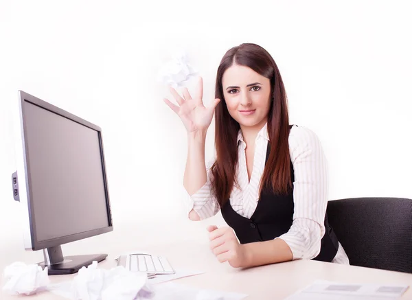 Mujer en su escritorio lanzando una bola de papel — Foto de Stock