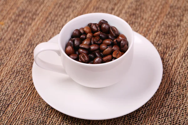 Coffee cup with fresh coffee beans on a brown background Stock Image