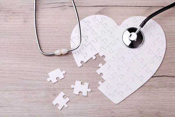 Puzzle a forma di cuore bianco con stetoscopio — Foto Stock