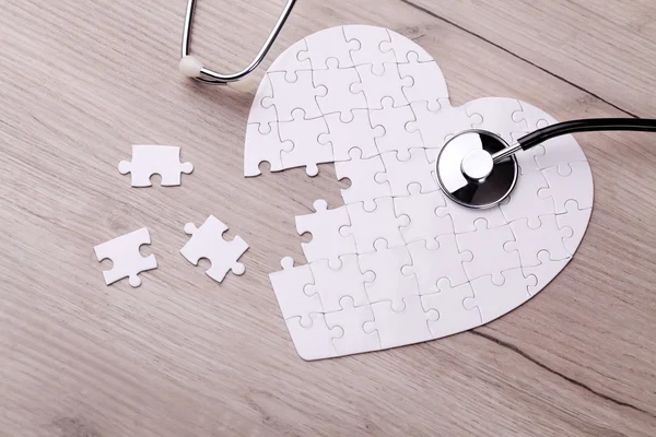 Stethoscoop op puzzel, oplossing van het mysterie van de gezondheidszorg — Stockfoto