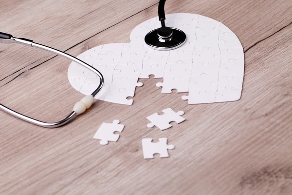 聴診器で白いハート形のパズル — ストック写真