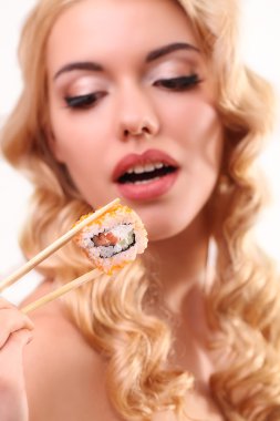 Bir ton balığı maki sushi tutan güzel kadın. Suşi mi odakta, mo