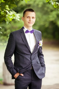 Gülümseyen ve gelin için bekleyen düğün smokin, yakışıklı damat.