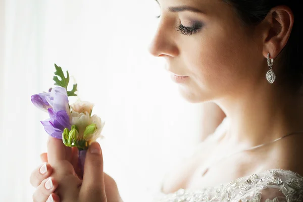 Happy bride dalam gaun pengantin dengan bunga di dekat jendela cerah — Stok Foto