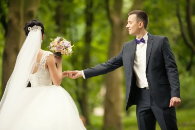 damat ve gelin elinde eller üzerinde arka plan yeşil orman