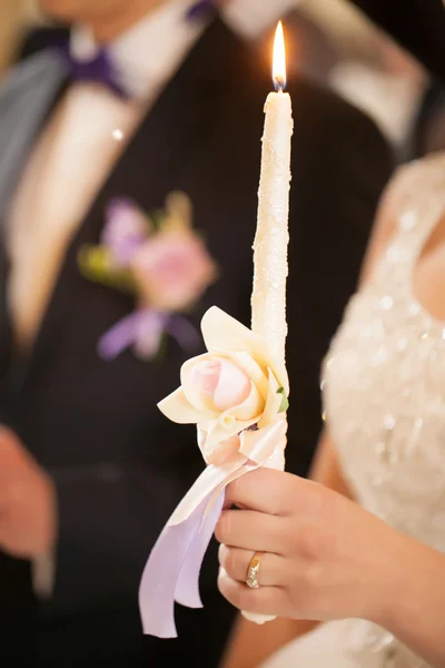 Lighted candle at the wedding ceremony in the church. Hand close — Stock Photo, Image