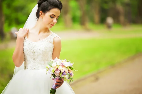 Retrato de una hermosa novia en un exuberante jardín — Foto de Stock