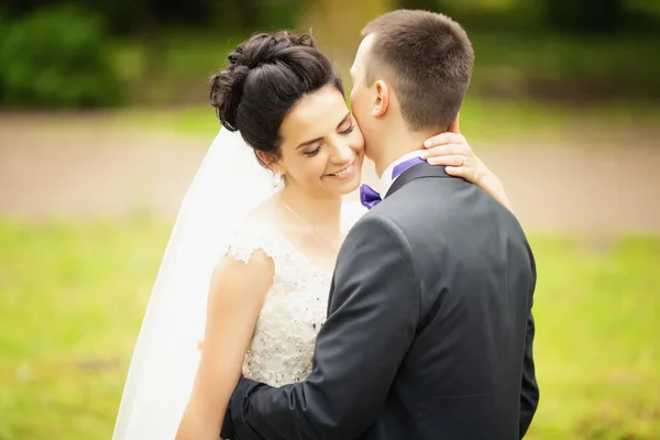 Sposa e sposo a piedi baci vicino agli alberi — Foto Stock