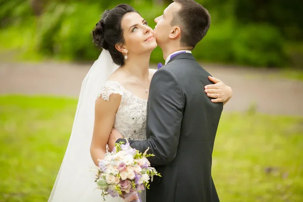 Portrait rapproché d'un couple nouvellement marié embrassant au parc — Photo