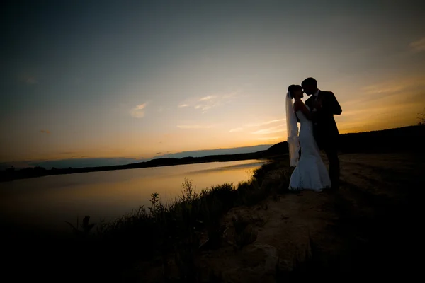Brudgummen och bruden är kramas och kyssas på bakgrunden vacker — Stockfoto