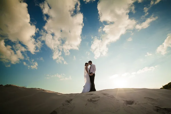 Ευτυχισμένη νύφη και τον γαμπρό σε μια όμορφη παραλία στο ηλιοβασίλεμα — Φωτογραφία Αρχείου