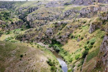 İtalya, Basilicata 'da Matera' nın bulunduğu Gravina Nehri tarafından oyulmuş bir kanyon. İtalya 'nın Matera kenti, Paleolitik dönemden beri ikamet eden antik mağara evleriyle tanınıyor.. 