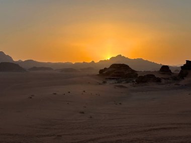 Wadi Rum manzarası ve günbatımı, Jordan. Wadi Rum, Ürdün 'ün güneyinde, Akabe' nin yaklaşık 60 km doğusunda yer alan ve kumtaşı ve granit kayalara kesilen bir vadi.