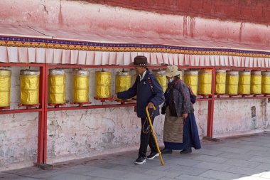 Çin 'in Tibet Özerk Bölgesi' nin başkenti Lhasa 'daki bir müze kompleksi olan Potala Sarayı' nda iki hacı dua çarkını döndürüyor. Eskiden Dalai Lamas 'ın kış sarayıydı.