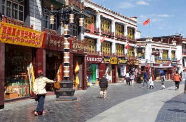 Lhasa City, Tibet, Çin 'deki Barkhor çevre yolu boyunca insanlar, binalar ve dükkanlar. Lhasa, Çin 'in Tibet Özerk Bölgesinin başkentidir..