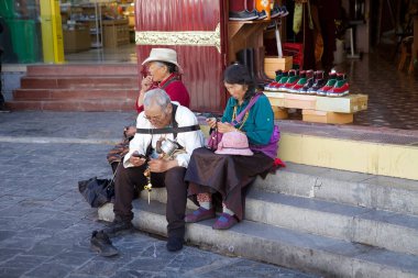 Tibetli hacılar Çin 'in Tibet, Lhasa şehrindeki Barkhor çevre yolunda dinleniyorlar. Lhasa, Çin 'in Tibet Özerk Bölgesinin başkentidir..