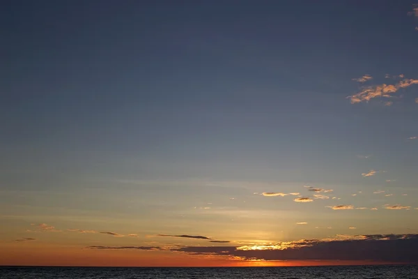 Wolkenlandschaft und Sonnenuntergang über dem Meer — Stockfoto