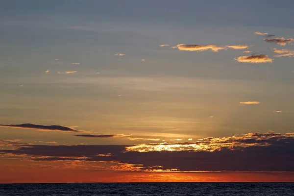 Wolkenlandschaft und Sonnenuntergang über dem Meer — Stockfoto