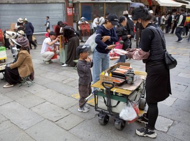 Sokak satıcısı cadde boyunca Tibet, Tibet 'te yemek pişirip satıyor. Lhasa, Çin 'in Tibet Özerk Bölgesinin başkentidir..