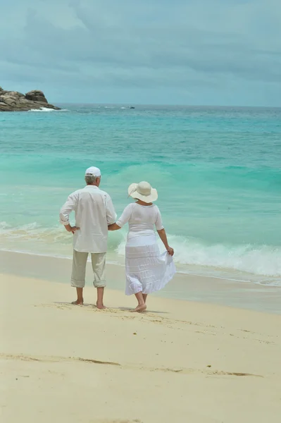 Elderly couple rest at tropical beach — Stock Photo, Image