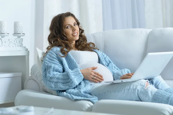 Hermosa mujer embarazada y portátil —  Fotos de Stock