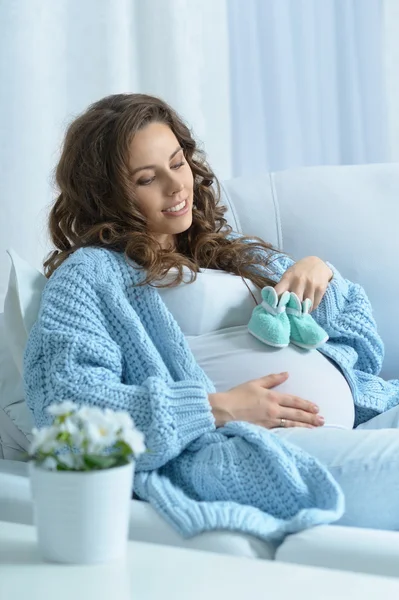 Femme enceinte avec des chaussures de bébé — Photo