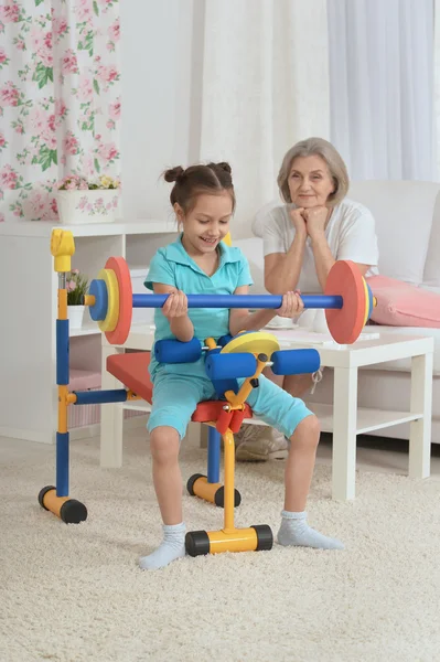 Little granddaughter doing exercise — Stock Photo, Image