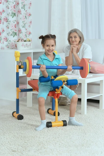 Little granddaughter doing exercise — Stock Photo, Image