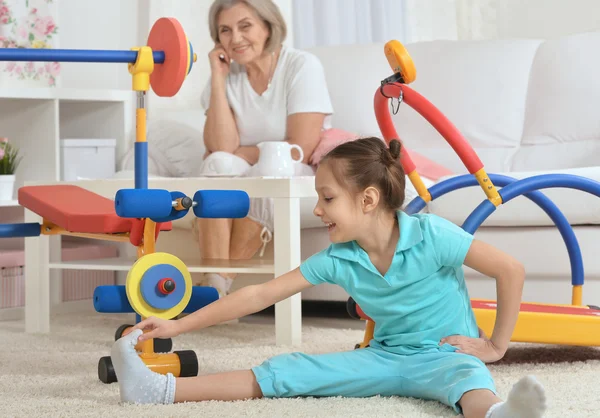 Little granddaughter doing exercise — Stock Photo, Image