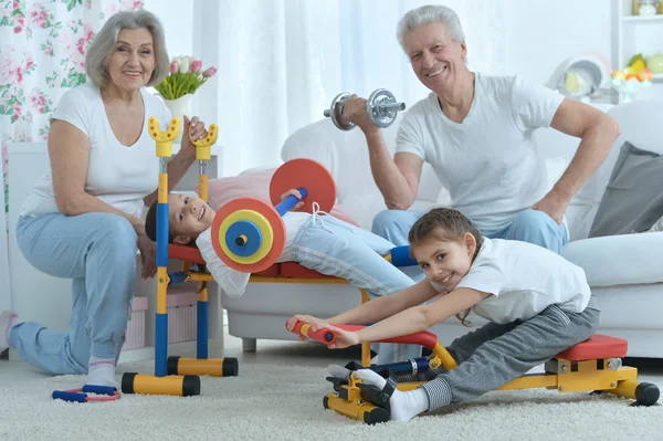 Far-och morföräldrar och barnbarn gör övning — Stockfoto