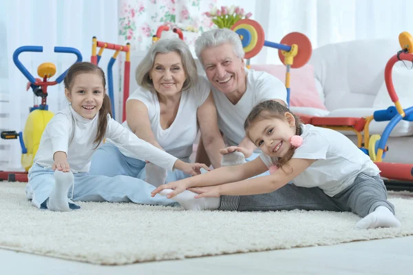 Far-och morföräldrar och barnbarn gör övning — Stockfoto