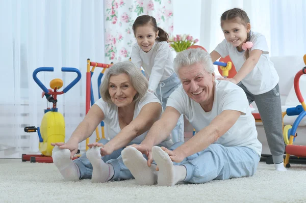 Far-och morföräldrar och barnbarn gör övning — Stockfoto