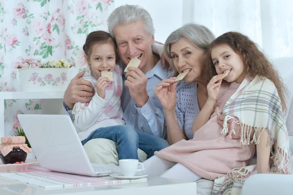 Pareja de ancianos con nietos y portátil —  Fotos de Stock