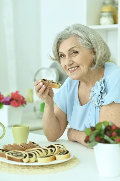 Lezzetli pasta ile üst düzey kadın — Stok fotoğraf