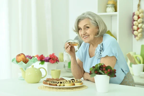 Seniorin mit leckerem Kuchen — Stockfoto