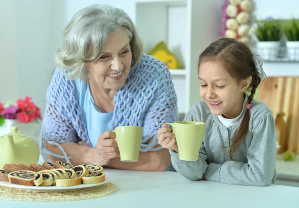Senior vrouw met kleindochter met thee — Stockfoto