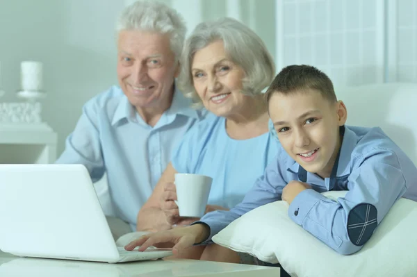 Menino com seus avós e laptop — Fotografia de Stock