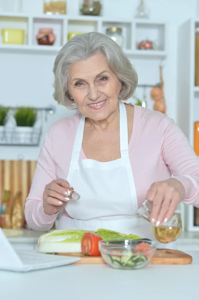 Ηλικιωμένη γυναίκα μαγειρεύει στην κουζίνα — Φωτογραφία Αρχείου
