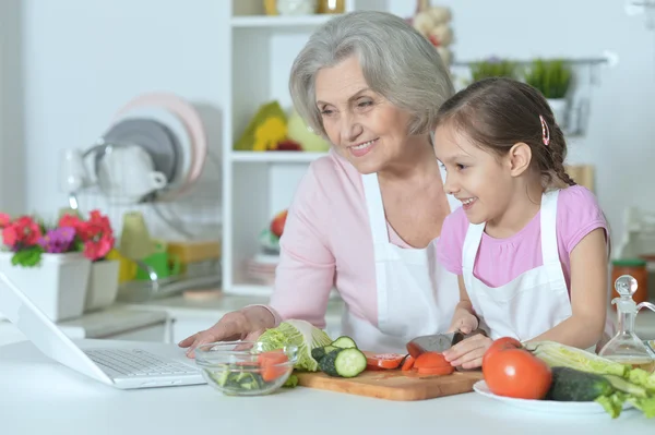 Senior vrouw met kleindochter koken — Stockfoto