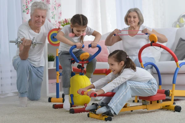 Far-och morföräldrar och barnbarn gör övning — Stockfoto