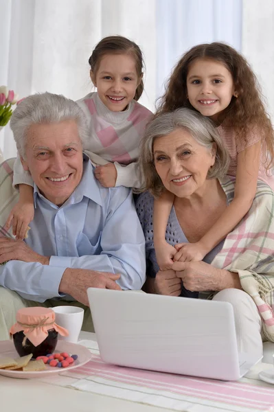 Seniorenpaar mit Enkeln und Laptop — Stockfoto