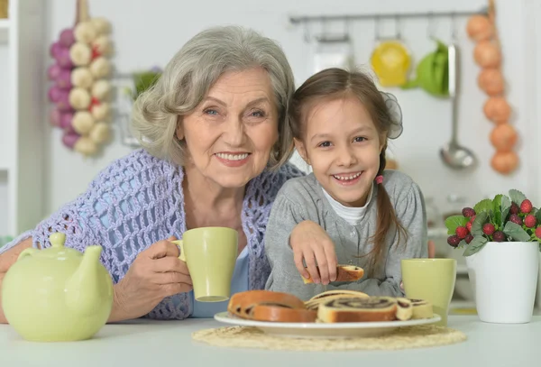 Senior woman with granddaughter with tea — Stock Photo, Image