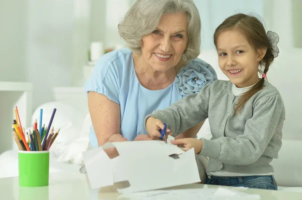 Бабушка с внучкой режут вместе — стоковое фото