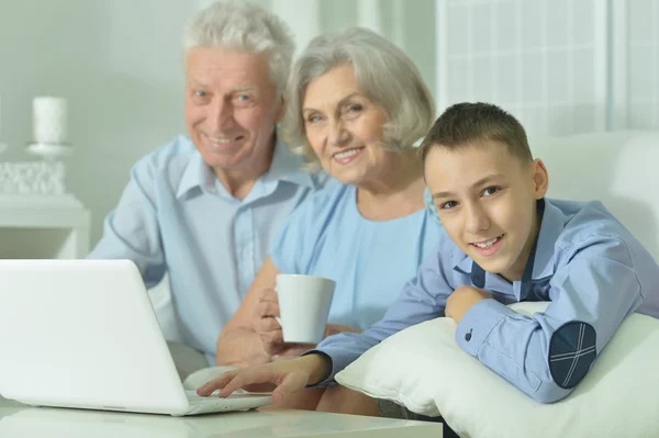 Garçon avec ses grands-parents et ordinateur portable — Photo